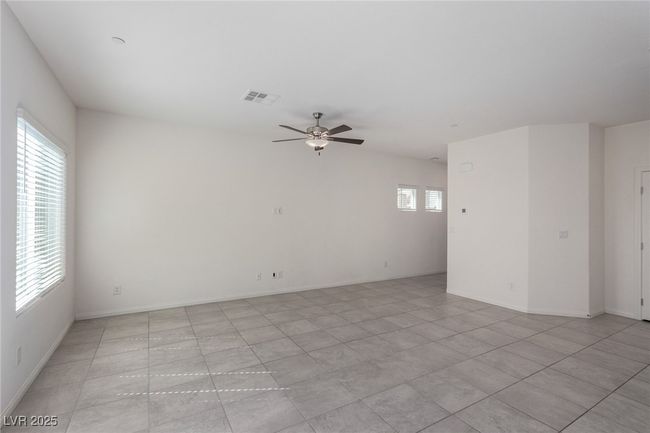 Empty room with visible vents, ceiling fan, light tile patterned floors, and baseboards | Image 6