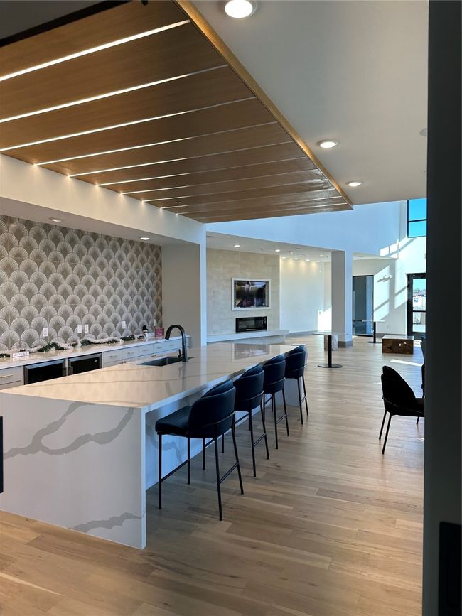 Bar area featuring an accent wall, wallpapered walls, light wood-style flooring, and recessed lighting | Image 15