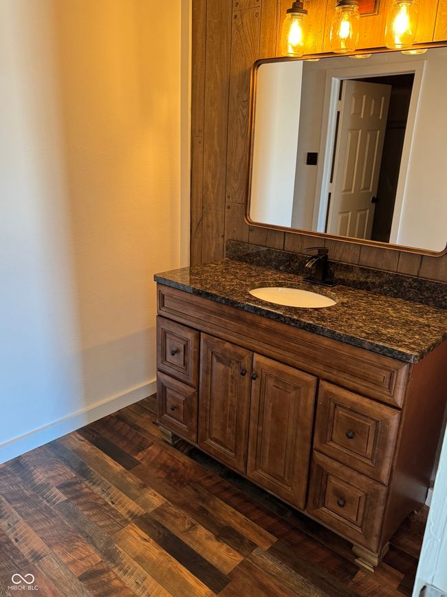 bathroom with baseboards, wood finished floors, and vanity | Image 12