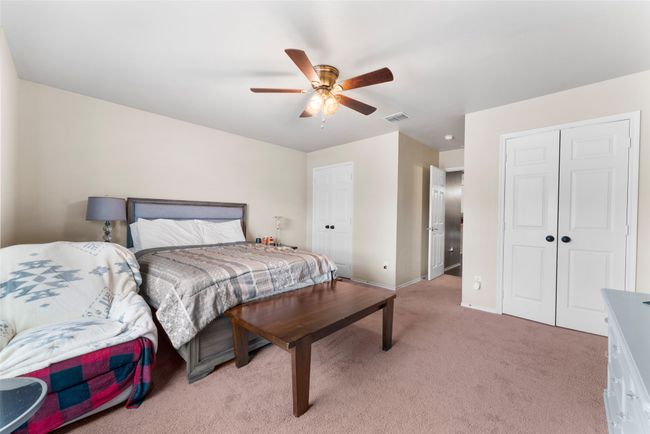 Bedroom with baseboards, ceiling fan, visible vents, and light colored carpet | Image 16