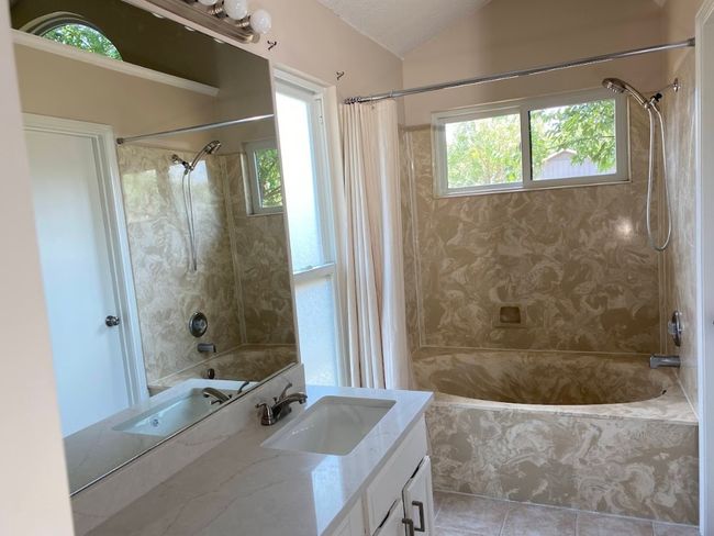 Primary bath with dual vanity, soaking tub, multiple closets, and separate toilet. | Image 9