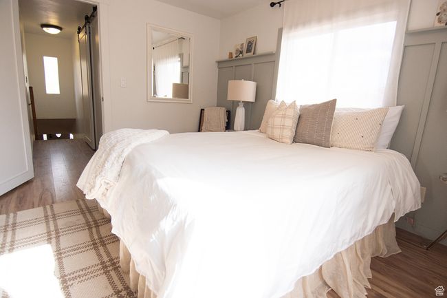 Bedroom featuring wood finished floors and a barn door | Image 14