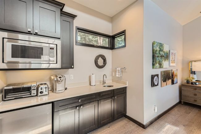 Kitchen featuring light wood-type flooring, stainless steel microwave, and light countertops | Image 4