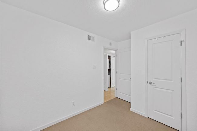Unfurnished bedroom with light carpet and baseboards | Image 12