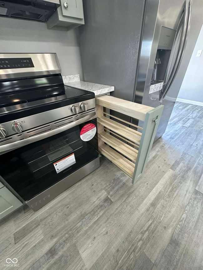 kitchen with ventilation hood, vinyl plant waterproof flooring, and stainless-steel range with electric stovetop and pull out drawers! | Image 7