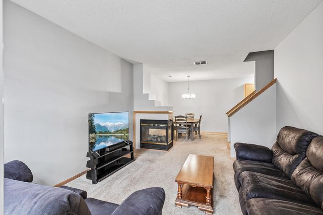 Living room separated from dining room by the 3 sided gas fireplace | Image 4