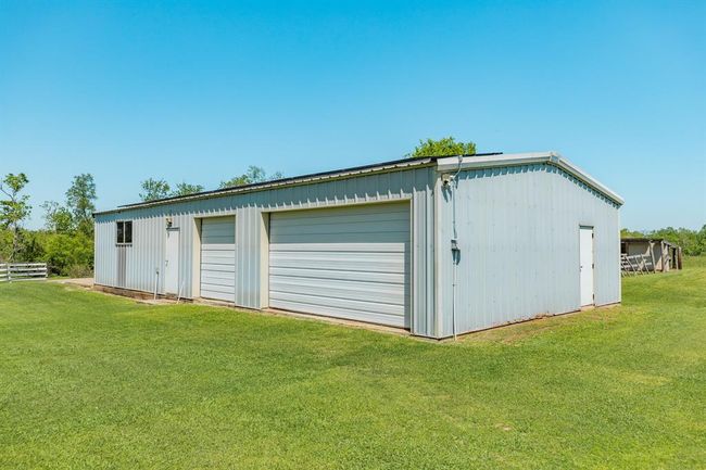 This shop has space for 3 vehicles and two separate entrances. It also has a large concrete pad on the side of the building where the Owner had a raised bed gardening site. | Image 43