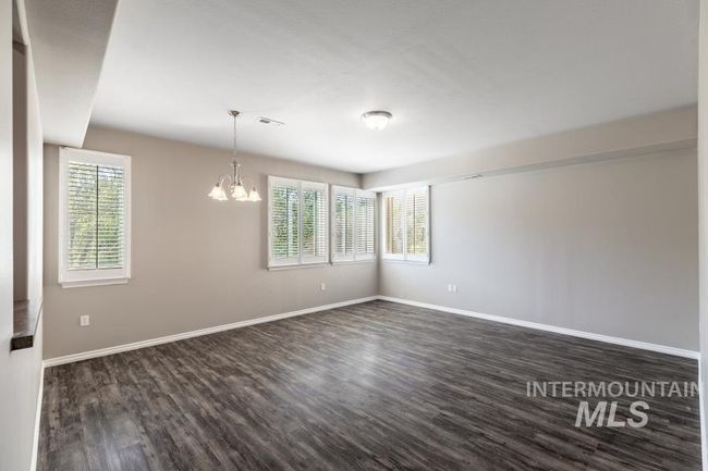Unfurnished room with a chandelier, plenty of natural light, and dark wood-type flooring | Image 9