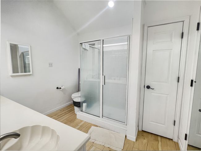 Full bathroom featuring a shower stall, vanity, and wood finished floors | Image 9