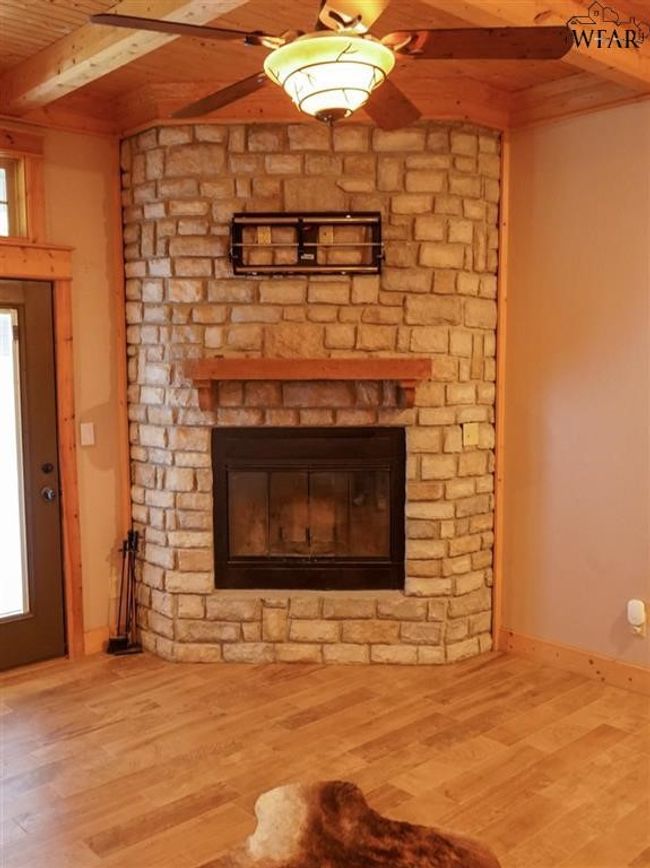 Interior details with a stone fireplace, wooden ceiling, beamed ceiling, and hardwood / wood-style floors | Image 7
