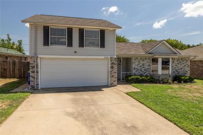 View of front of property featuring a garage and a front lawn | Image 1