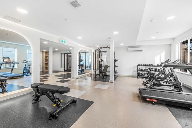 Workout area featuring visible vents, a wall unit AC, recessed lighting, arched walkways, and baseboards | Image 30