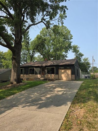 Ranch-style home featuring a front yard and a garage | Image 2