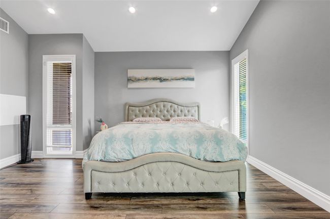Bedroom with wood finished floors, baseboards, recessed lighting, and vaulted ceiling | Image 16