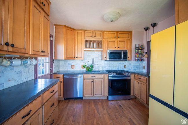 Kitchen with a sink, dark wood finished floors, dark countertops, and stainless steel appliances | Image 5