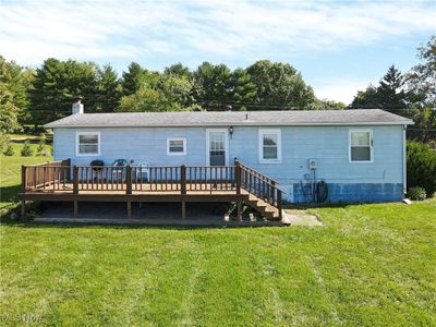 View of front facade with a deck and a front lawn | Image 1