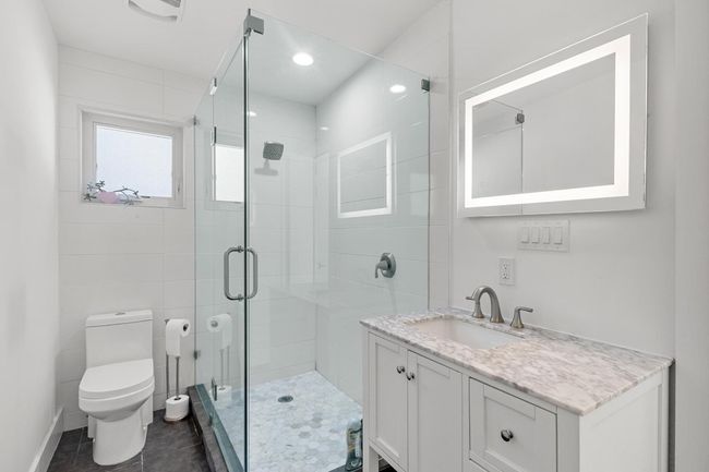 Full bathroom featuring vanity, visible vents, toilet, a stall shower, and tile patterned floors | Image 19