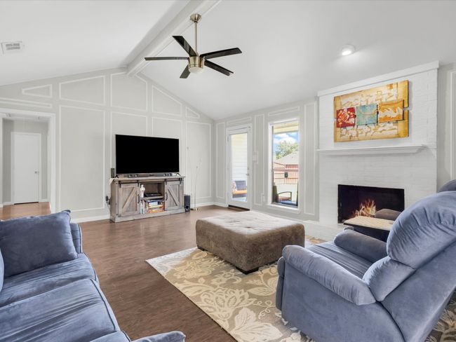 Living area with a ceiling fan, a fireplace, and wood finished floors | Image 10