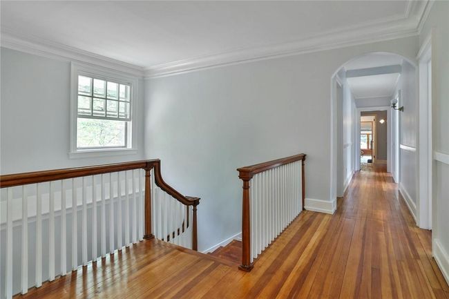 Upper landing hall with crown molding and framed by graceful archways | Image 26