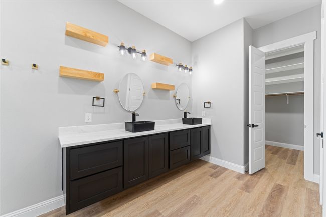 Full bathroom with baseboards, double vanity, a sink, and wood finished floors | Image 18