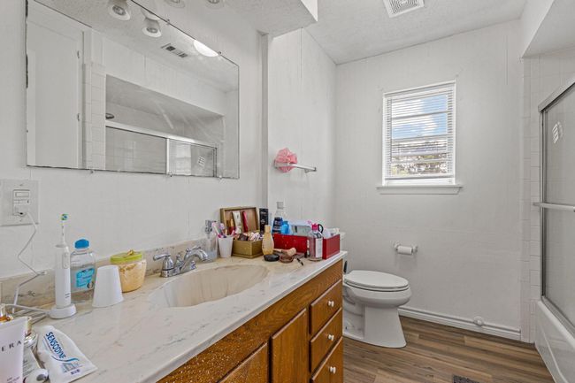 Full bath featuring vanity, wood finished floors, and enclosed tub / shower combo | Image 26