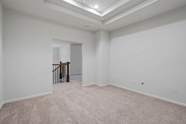 Unfurnished room featuring a raised ceiling, light carpet, baseboards, visible vents, and recessed lighting | Image 26