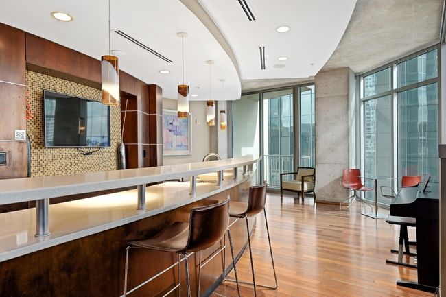 Bar featuring pendant lighting, light wood-style flooring, a wall of windows, backsplash, and recessed lighting | Image 27