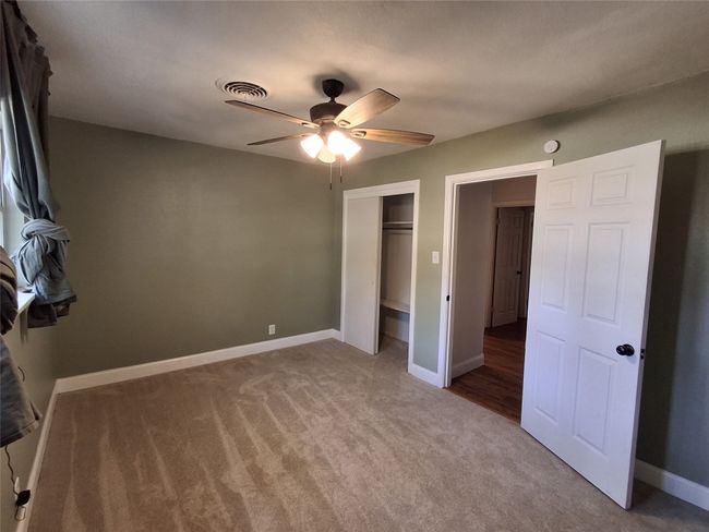 Unfurnished bedroom with carpet flooring, a closet, baseboards, and ceiling fan | Image 20