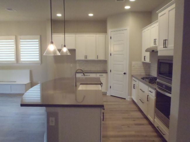 Kitchen with appliances with stainless steel finishes, recessed lighting, decorative backsplash, wood finished floors, and white cabinetry | Image 14