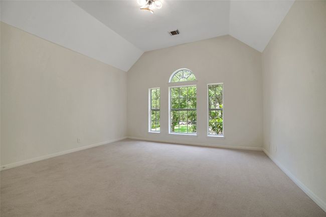 Spare room with light carpet, baseboards, and lofted ceiling | Image 13