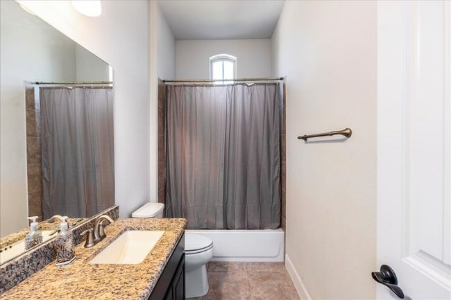 Bathroom with vanity, shower / tub combo, and tile patterned flooring | Image 22