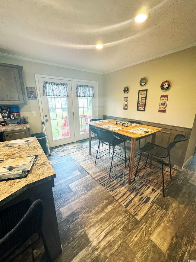 Dining space featuring ornamental molding, dark wood-style floors, a textured ceiling, and french doors | Image 16