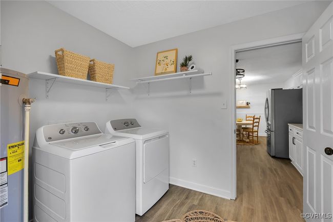 Laundry room with separate washer and dryer, wood finished floors, water heater, and baseboards | Image 22