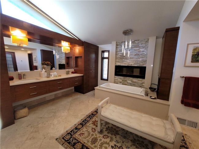 Full bathroom with vaulted ceiling, a sink, a garden tub, a fireplace, and visible vents | Image 28
