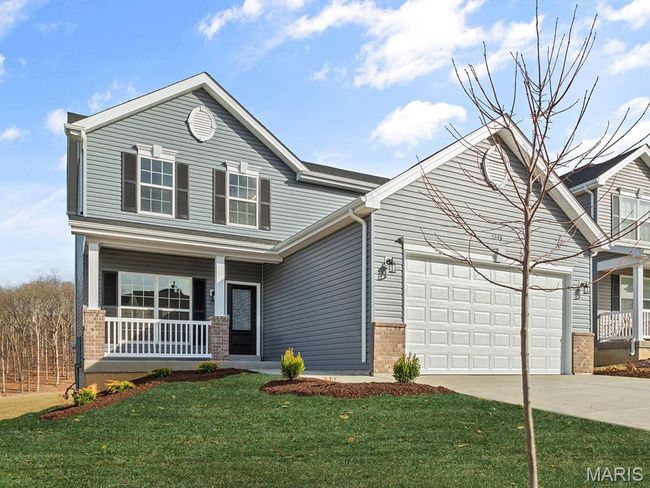 View of front of house with a porch, brick siding, driveway, an attached garage, and a front yard | Image 25