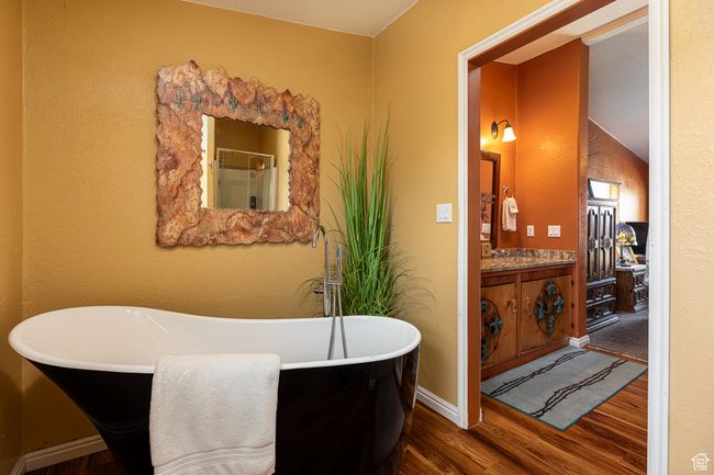 Bathroom with wood-type flooring, a bathing tub, and vanity | Image 16