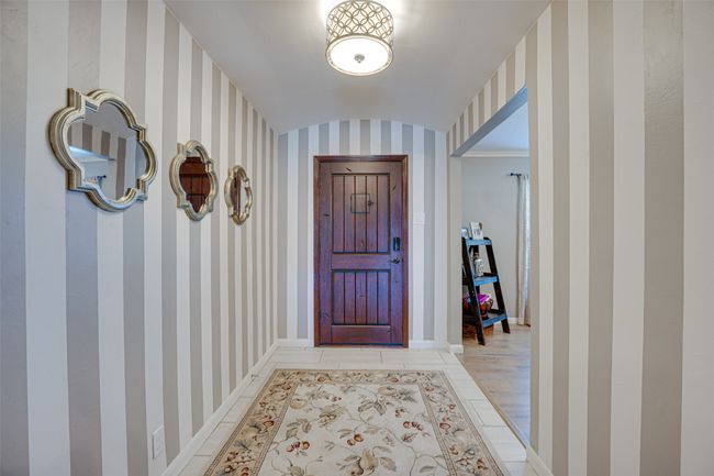 Foyer with wallpapered walls and lofted ceiling | Image 4