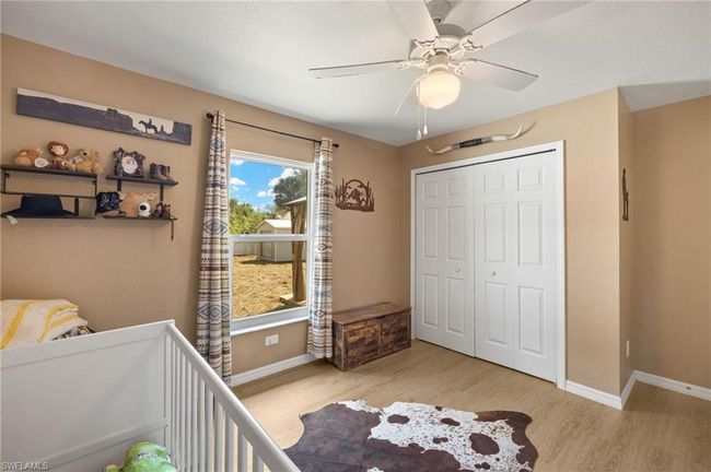 Bedroom with baseboards, wood finished floors, a closet, and a ceiling fan | Image 16