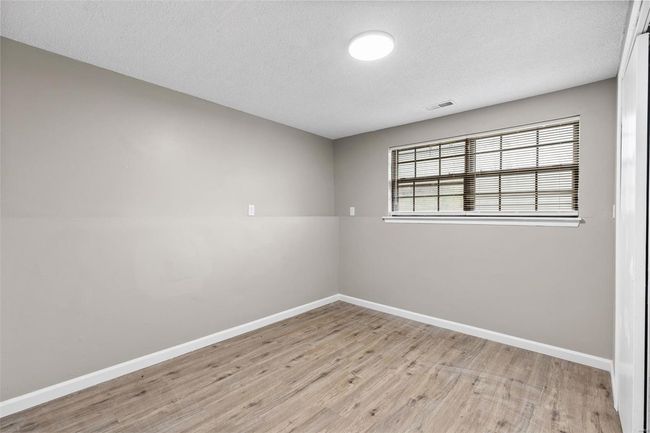 Spare room featuring wood finished floors, a textured ceiling, baseboards, and visible vents | Image 28