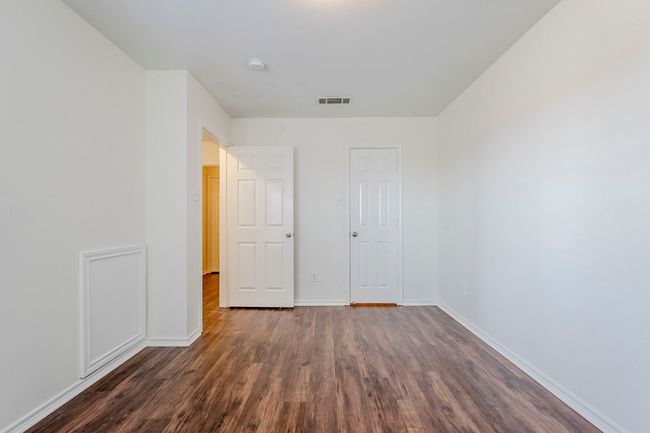 Unfurnished bedroom featuring dark wood-style flooring and baseboards | Image 23