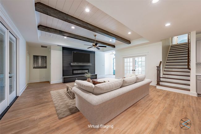 Living room featuring light hardwood / wood-style flooring, ceiling fan, a fireplace, french doors, and beamed ceiling | Image 9