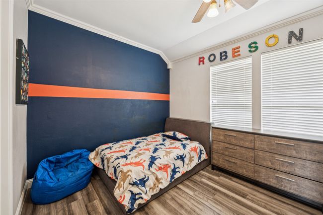 Bedroom with wood finished floors, ornamental molding, and a ceiling fan | Image 14