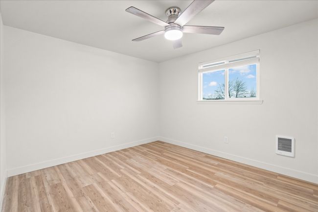 Spare room with light wood-style floors, a ceiling fan, and heating unit | Image 13