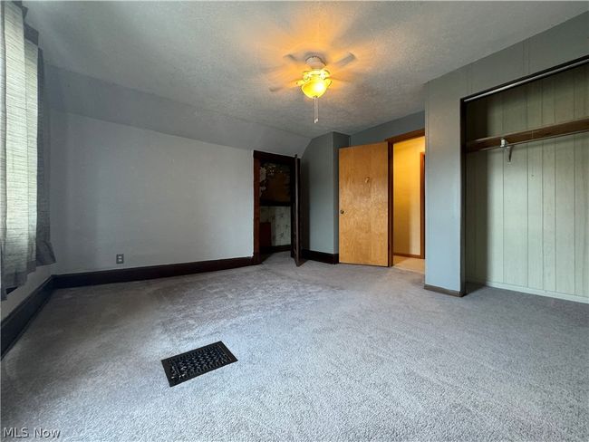 Unfurnished bedroom with a textured ceiling, a closet, carpet, and ceiling fan | Image 23
