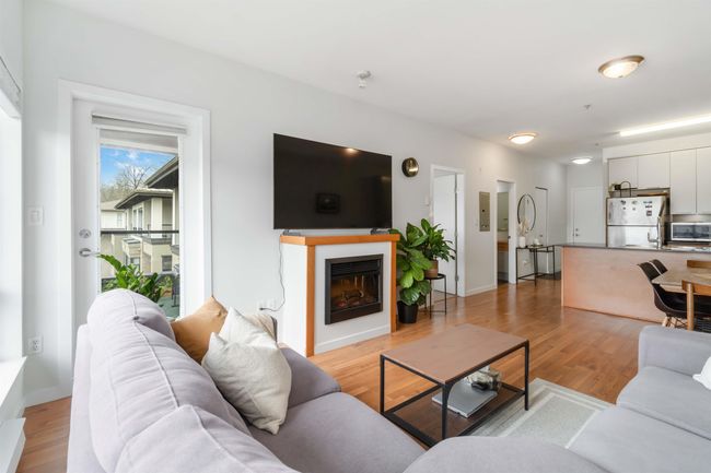 Living area with a fireplace, light wood-style flooring, and baseboards | Image 9