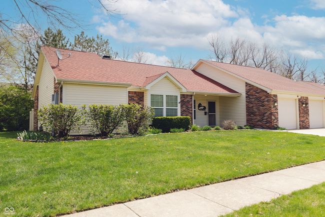ranch-style home with a shingled roof, concrete driveway, brick siding, a front yard, and a garage | Image 31