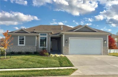 View of front facade with a garage and a front lawn | Image 1