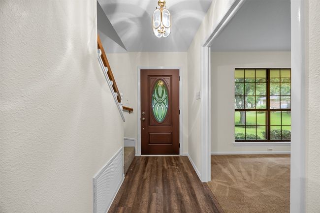 Foyer featuring a chandelier, baseboards, a textured wall, and carpet flooring | Image 5