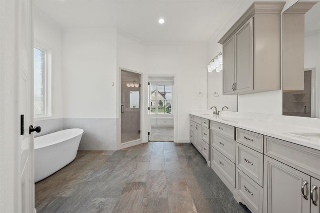 Full bath with double vanity, a freestanding tub, crown molding, a stall shower, and recessed lighting | Image 21