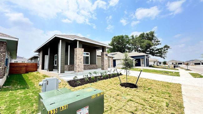 View of front of home featuring a porch, driveway, a front yard, brick siding, and fence | Image 4